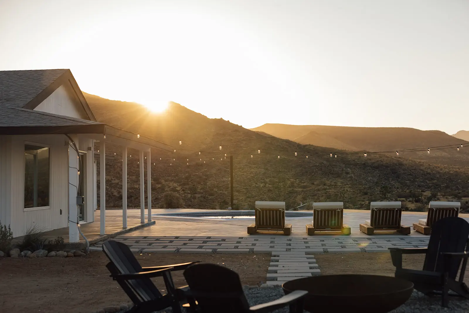 Infinity pool spilling toward desert horizon at sunset