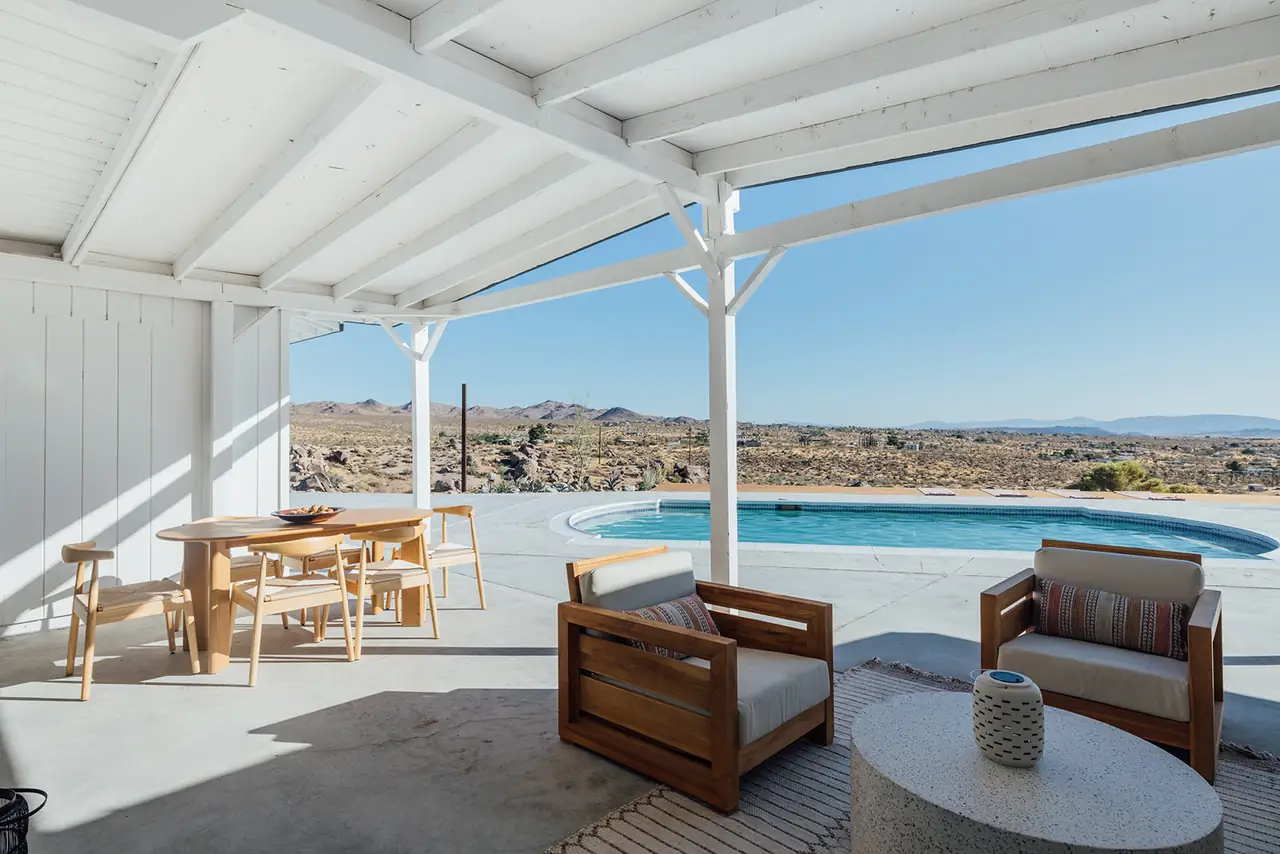 Covered patio lounge opening to pool and desert horizon